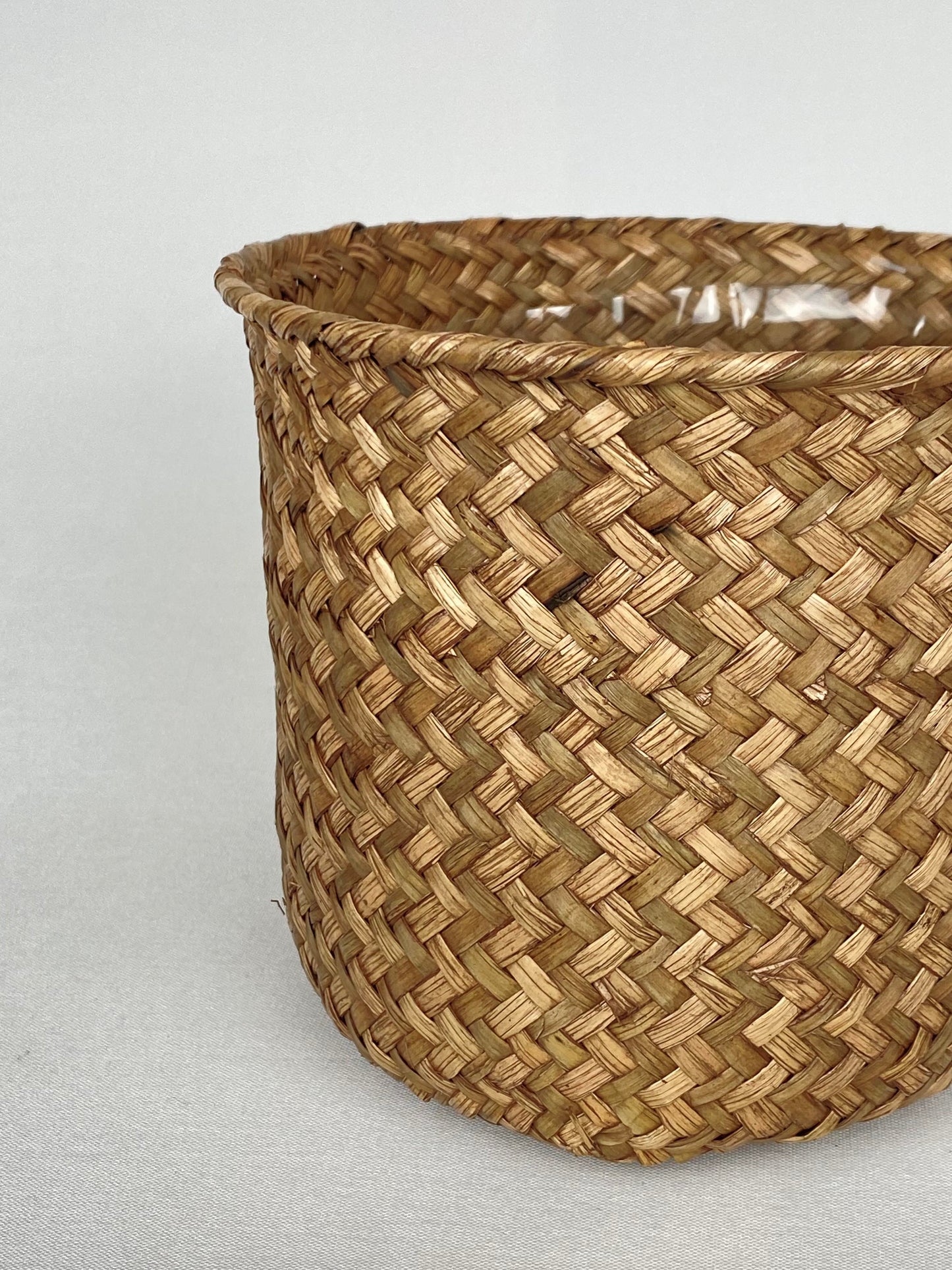 Flätad kruka i naturmaterial mellan