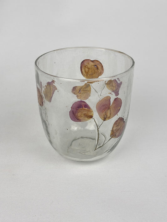 Ljuslykta i glas med torkade blomblad